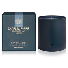 Load image into Gallery viewer, A navy blue scented candle in a matte cylindrical container sits beside its branded dark teal box. The box reads Charles Farris Grand Cascade and shows the brand crest and product details.
