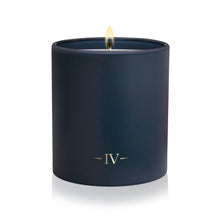 Load image into Gallery viewer, A single matte navy blue candle in a matching cylindrical container, lit with a visible flame and featuring a gold Roman numeral IV logo near the base, set against a clean white background.
